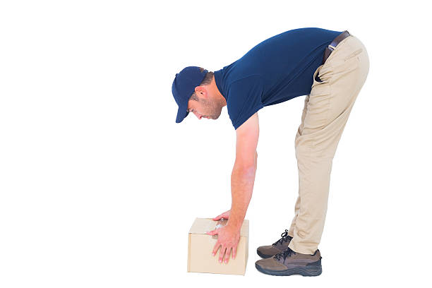 istock Side view of delivery man picking cardboard box 477659658