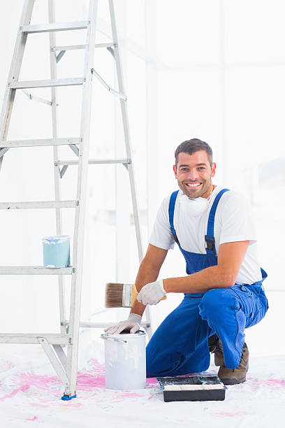 istock Smiling handyman with paintbrush and can at home 477660508