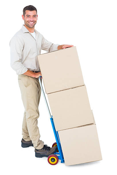 istock Happy delivery man with trolley of boxes 477663038