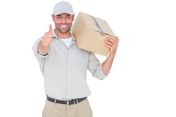 istock Delivery man with cardboard box gesturing thumbs up 477663296