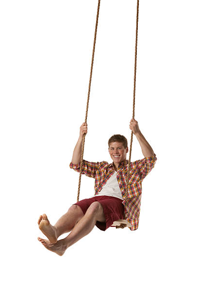 istock Happy man swinging on rope swing 477665523