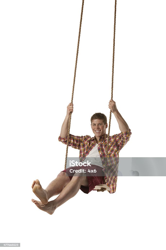 Happy man swinging on rope swing Happy man swinging on rope swinghttp://www.twodozendesign.info/i/1.png Men Stock Photo