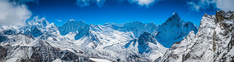 Sweeping panoramic vista across the high altitude peaks of the Khumbu, from the summit pyramids of Makalu (8481m), Baruntse (7219m) and Ama Dablam (6856m) overlooking the fluted hanging glaciers of Island Peak (6189m) and the Amphu Labsta pass deep in the mountain wilderness of the Himalayas, Nepal. ProPhoto RGB profile for maximum color fidelity and gamut.