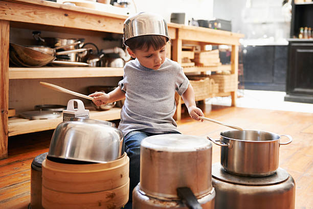 Check out my awesome drumming technique! A young boy playing drums on pots and pans drum percussion instrument stock pictures, royalty-free photos & images