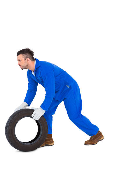istock Mechanic holding tire on white background 477669428