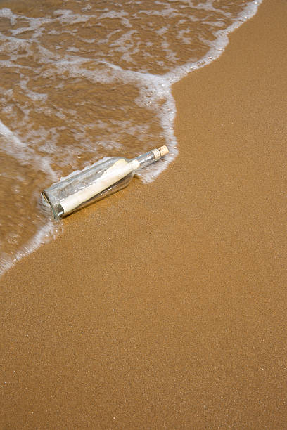 Message in a bottle Message in a bottle washing up on the beach ocean beach papua new guinea stock pictures, royalty-free photos & images