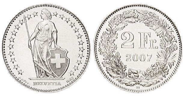 zwei swiss francs auf weißem hintergrund - swiss currency swiss francs currency swiss coin stock-fotos und bilder