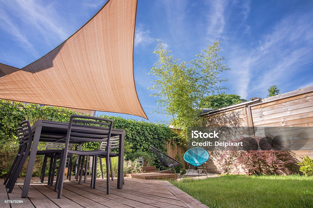 Modern house terrace in summer with table and shade sail Shade Stock Photo