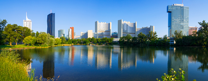 Panoramic view at skyscrapers of the VIC (Vienna International Centre) and their reflection in a pond