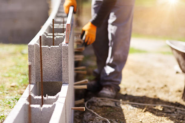 Man building a house Bricklayer putting down another row of bricks in site bricklayer stock pictures, royalty-free photos & images