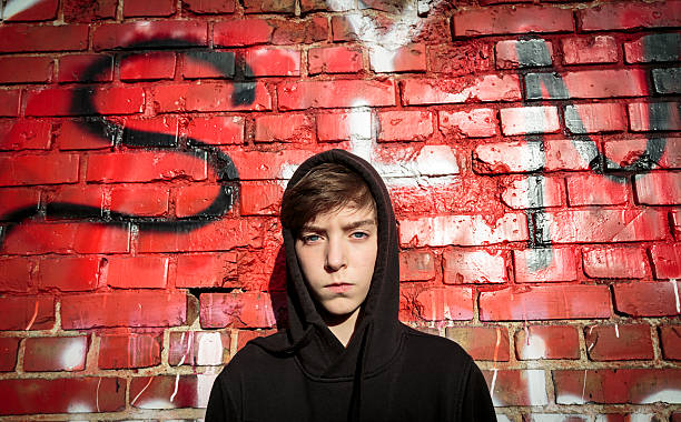 istock teenage boy in front of a red graffiti 477679360