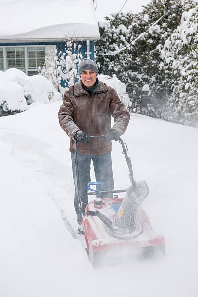istock Man clearing driveway with snowblower 477682559