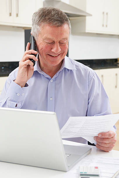 istock Senior Man On Phone Checking Personal Finances 477688569