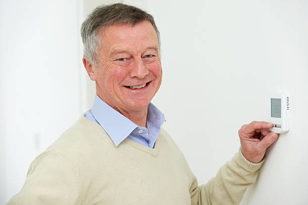istock Senior Man Adjusting Central Heating Thermostat 477688583