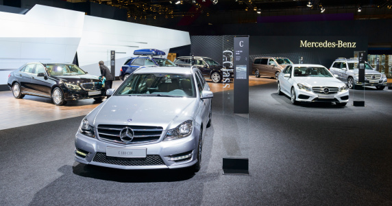 Brussels, Belgium - January 14, 2014: Various cars on display at the Mercedes Benz stand during the 2014 Brussels Motor Show. The Mercedes Benz C-class is on display in the foreground with the E-class, ML Class, GL class and GLK class in the background. People are watching the various cars.
