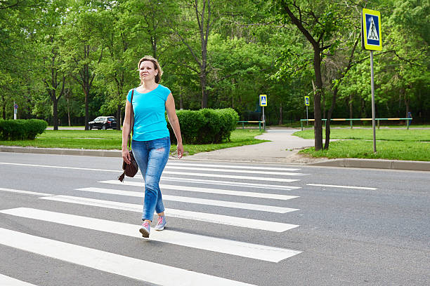 istock Young woman crossing road 477689020
