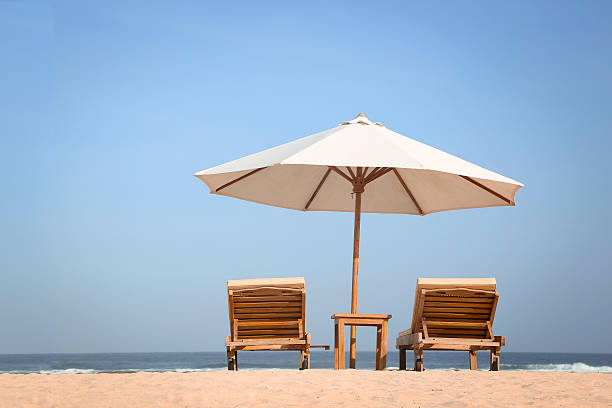 istock Tropical beach scenery with white parasol and chairs 477689772