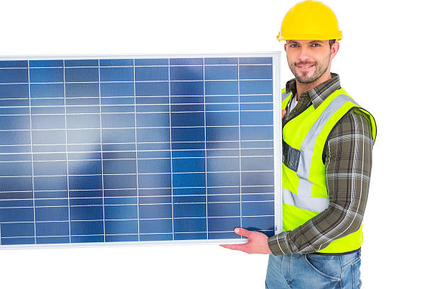 istock Handyman in protective clothing carrying solar panel 477692772