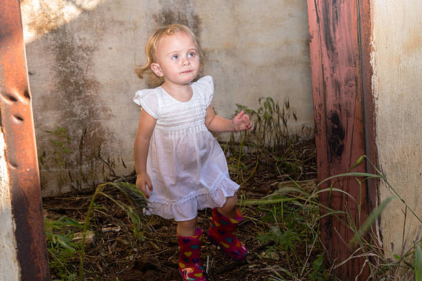 istock Baby girl looking up inside an abandoned home 477693209