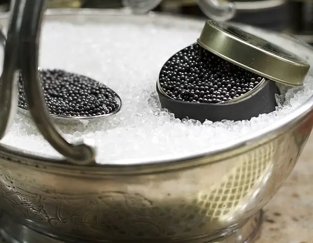 A bowl of black caviar served on crushed ice