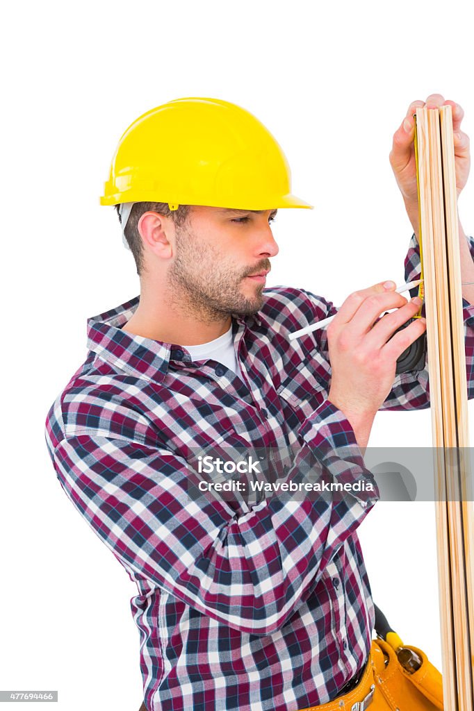 Handyman using measure tape to mark on wooden plank Handyman using measure tape to mark on wooden plank on white background 20-29 Years Stock Photo
