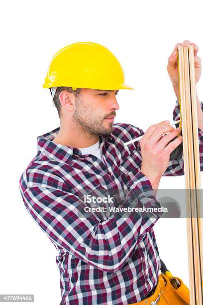 Handyman Using Measure Tape To Mark On Wooden Plank Stock Photo - Download Image Now