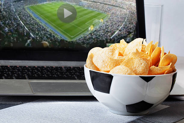 football bowl of chips at a computer with video broadcast stock photo
