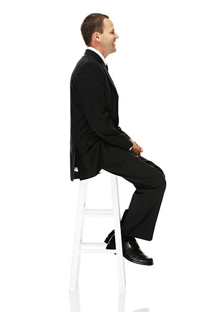 istock Side view of businessman sitting on stool 477695757