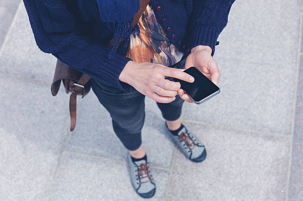 istock Young woman using smart phone outside 477696024