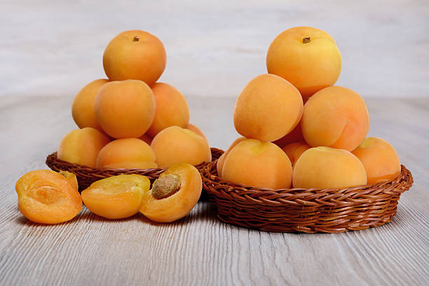 istock Two Wicker basket with apricots on wood 477696768