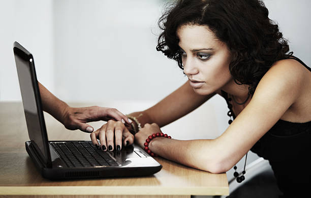 Feeding her delusion online A young woman looking at her laptop while a hand is coming out of the screen to touch her on the arm creepy stalker stock pictures, royalty-free photos & images