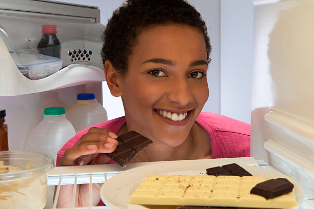 istock Young Girl Eating Chocolate from Fridge 477698381