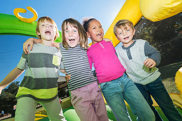 istock Four multi-ethnic children playing on bouncy castle 477699788