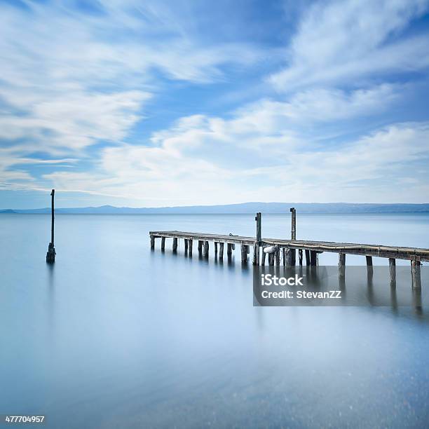 Wooden Pier Jetty Remains On A Blue Lake Long Exposure Stock Photo - Download Image Now