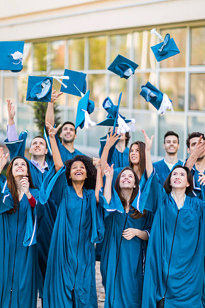 istock Happy graduation students throwing mortarboard hats in the air. 477706422