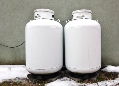 Two white propane tanks against green wall. Horizontal.-For more propane, click here.  PROPANE 