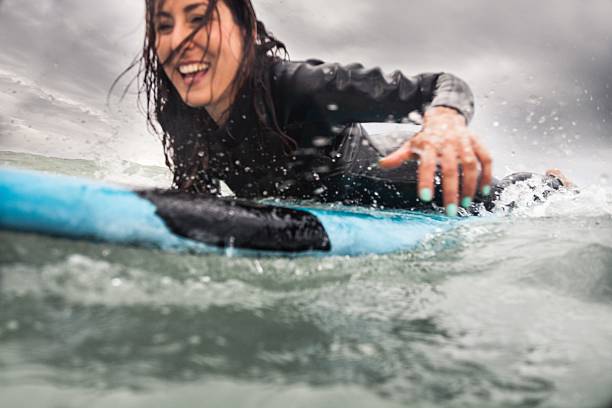 istock Woman surfing in the ocean 477708462