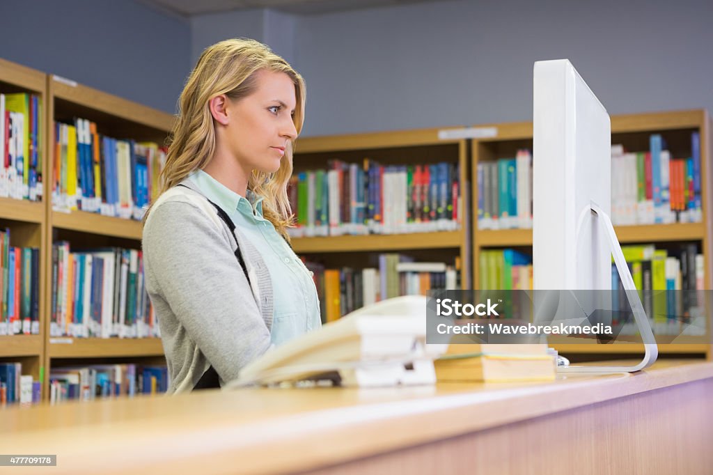 Pretty librarian working in the library Pretty librarian working in the library at the university Librarian Stock Photo