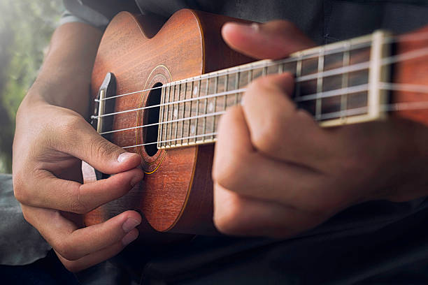 playing Ukulele A man playing ukulele in close up view. ukulele stock pictures, royalty-free photos & images