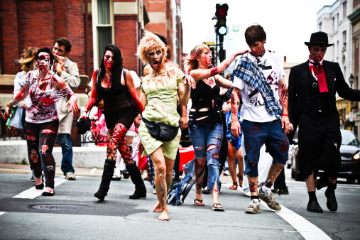 Halifax, Nova Scotia, Сanada - August 12, 2012: Participants of the Halifax Zombie Walk crossing the street at the intersection of Spring Garden Road and Barrington Street during the walk. Zombie Walks have become a somewhat regular occurance in some cities where people dress up and utilize makeup, fake blood etc and pretend to be zombies then walk on what is usually a pre-determined route throughout town.