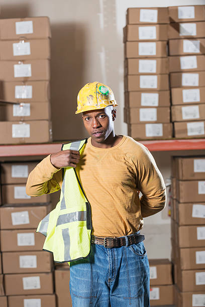 mann trägt sicherheit weste - minority african ethnicity business hardhat stock-fotos und bilder