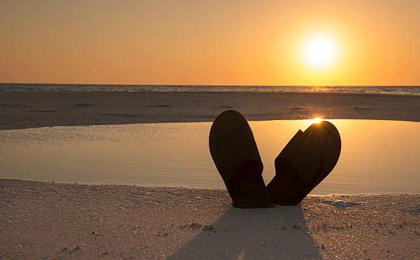 Sandals On The Beach By A Smooth Sunrise stock photo