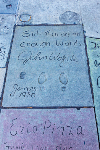 Los Angeles, USA - January 17, 2014:  The footprints of John Wayne in front of the famous Grauman's Chinese Theatre on Hollywood Boulevard.