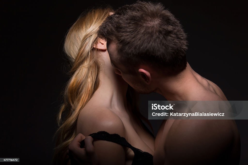 Passionate man undressing his lover Passionate man undressing and kissing his lover Kissing Stock Photo