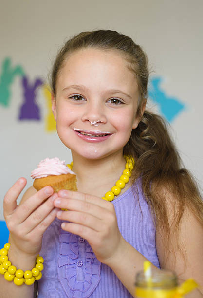 glückliches kleines mädchen essen cupcake - child portrait fine art portrait multi colored stock-fotos und bilder