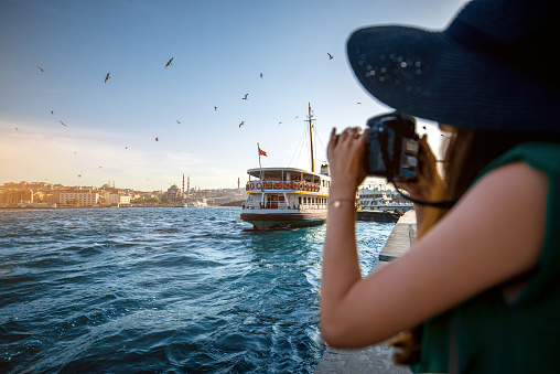 Young woman traveler in green dress and hat enjoying great view of the Bosphorus in Istanbul