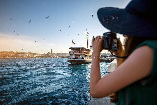 Woman traveler on the Bosphorus in Istanbul Young woman traveler in green dress and hat enjoying great view of the Bosphorus in Istanbul bosphorus stock pictures, royalty-free photos & images