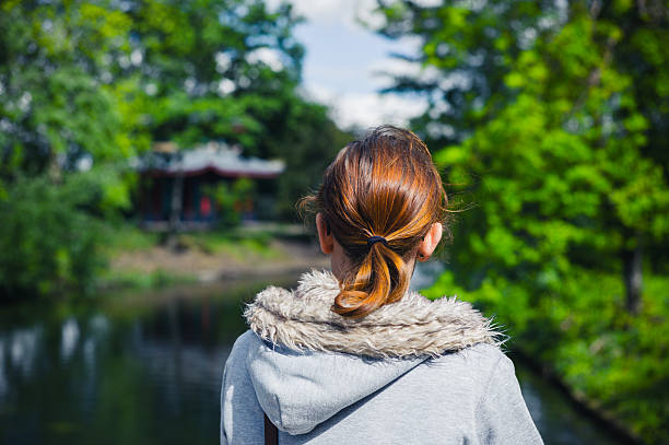 istock Woman by lake in park 477717798