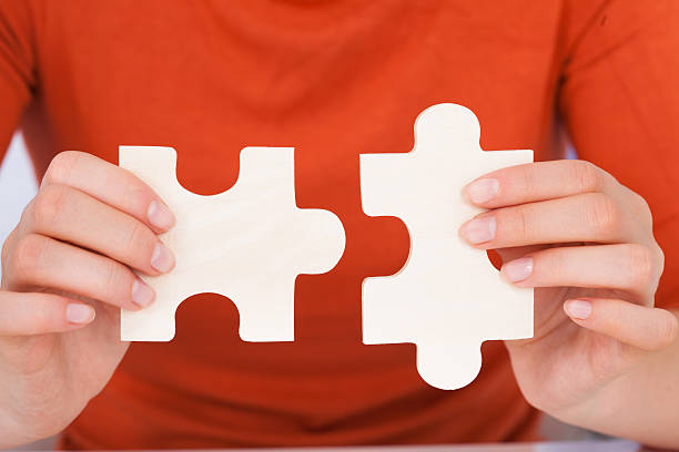 istock Businesswoman Fixing Jigsaw Pieces 477718634