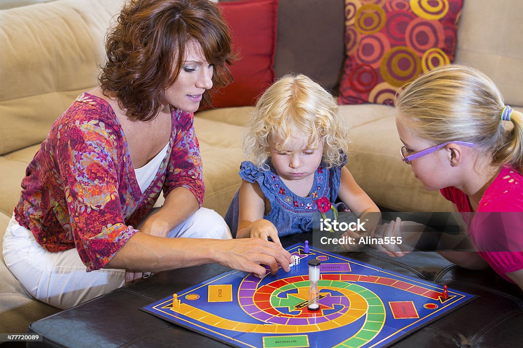 Mutter und zwei Kinder spielen ein Brettspiel zu Hause fühlen - Lizenzfrei Brettspiel Stock-Foto